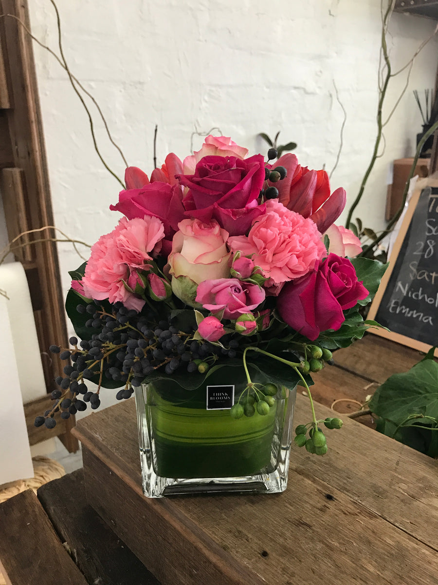 hot pink fresh posy in vase with bright pink color roses and other seasonal fresh flowers